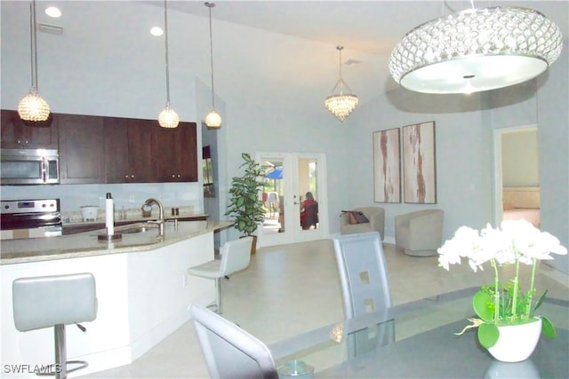 2640 36th Ave SE, Naples, FL 34117 - kitchen with appliances with stainless steel finishes, a sink, french doors, and decorative light fixtures