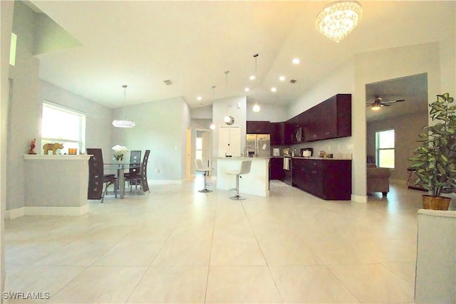 2640 36th Ave SE, Naples, FL 34117 - kitchen featuring stainless steel fridge with ice dispenser, a chandelier, a breakfast bar area, vaulted ceiling, and light countertops