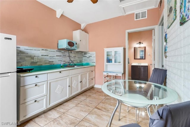 4617 Lombardy Ln, Naples, FL 34112 - kitchen featuring white appliances, white cabinets, backsplash, light countertops, and light tile patterned flooring