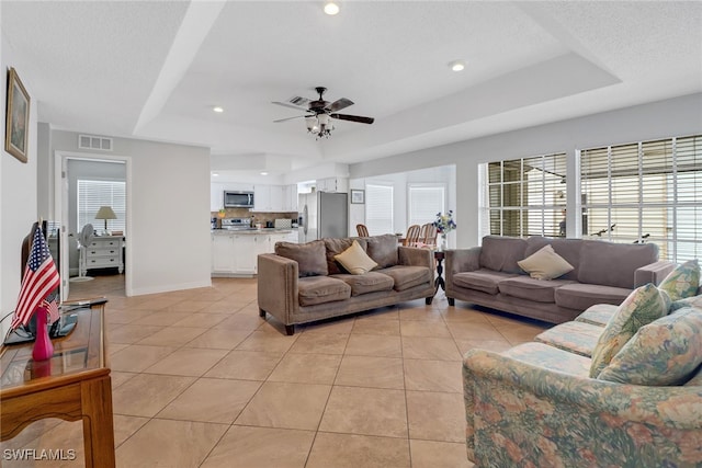 4617 Lombardy Ln, Naples, FL 34112 - living room with a tray ceiling, light tile patterned floors, a ceiling fan, recessed lighting, and baseboards