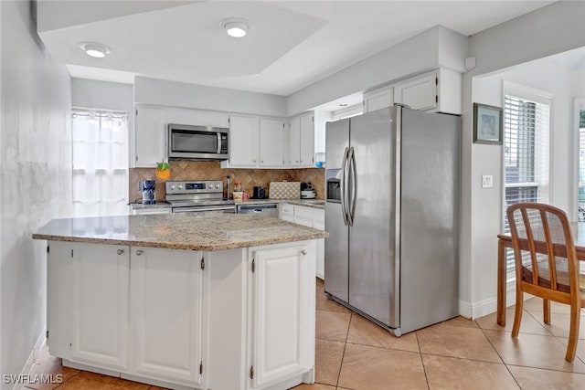 4617 Lombardy Ln, Naples, FL 34112 - kitchen with stainless steel appliances, light stone countertops, healthy amount of natural light, and white cabinetry