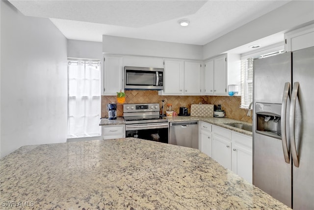 4617 Lombardy Ln, Naples, FL 34112 - kitchen featuring stainless steel appliances, a sink, light stone counters, and tasteful backsplash