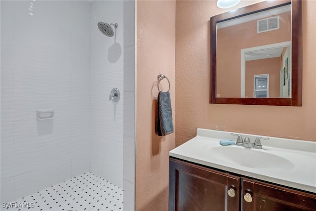 4617 Lombardy Ln, Naples, FL 34112 - bathroom with a tile shower, a textured wall, and vanity