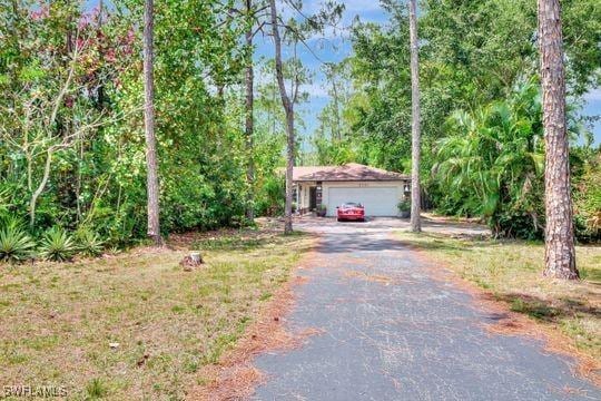 5251 Boxwood Way, Naples, FL 34116 - obstructed view of property with a garage and driveway