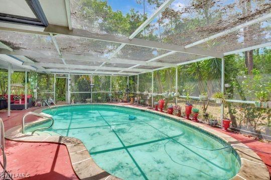 5251 Boxwood Way, Naples, FL 34116 - outdoor pool featuring glass enclosure and a patio