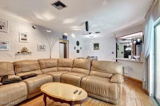 5251 Boxwood Way, Naples, FL 34116 - living room with light wood-type flooring, brick wall, and baseboards