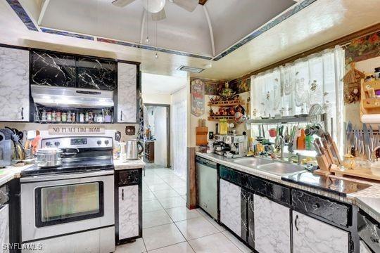 5251 Boxwood Way, Naples, FL 34116 - kitchen with appliances with stainless steel finishes, under cabinet range hood, lofted ceiling, light tile patterned flooring, and a sink