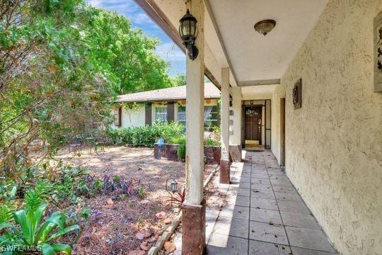 5251 Boxwood Way, Naples, FL 34116 - doorway to property with stucco siding