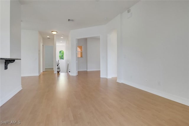 unfurnished living room featuring light wood-type flooring and baseboards