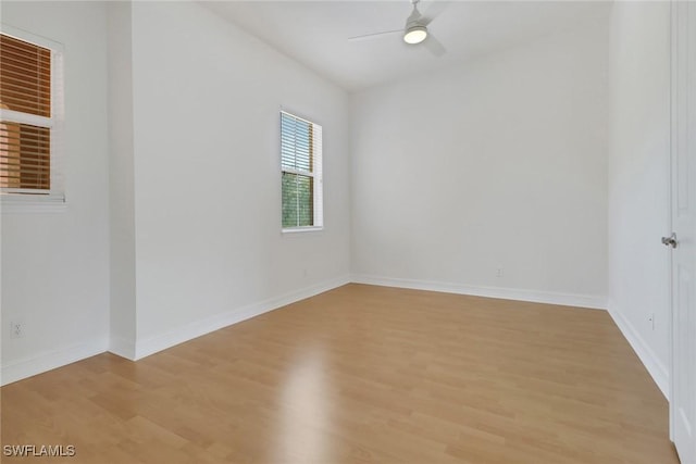 spare room with light wood-style floors, a ceiling fan, and baseboards