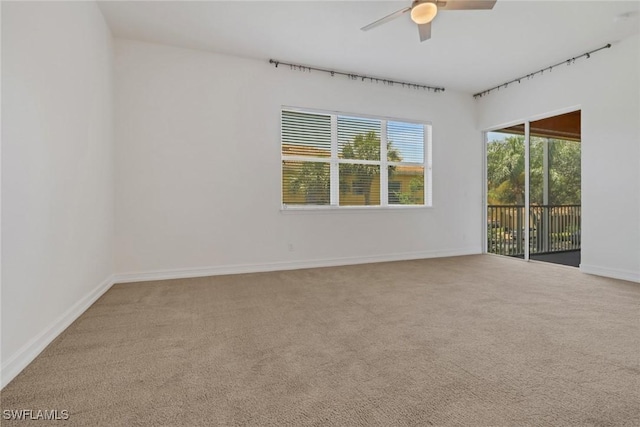 empty room with carpet floors, ceiling fan, and baseboards