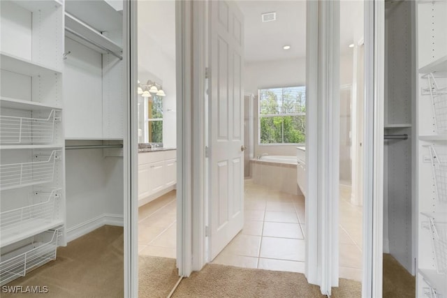 bathroom with a garden tub and tile patterned flooring
