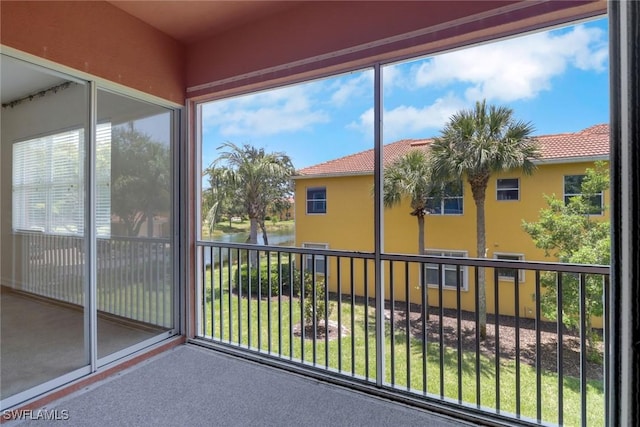 unfurnished sunroom featuring a water view