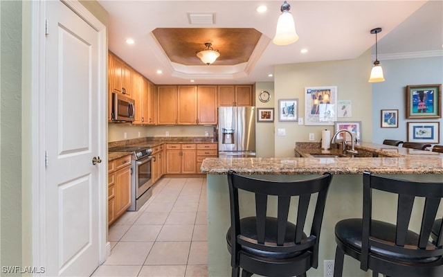 5704 Cape Harbour Dr Unit 105, Cape Coral, FL 33914 - kitchen with appliances with stainless steel finishes, a sink, a kitchen bar, stone counters, and hanging light fixtures