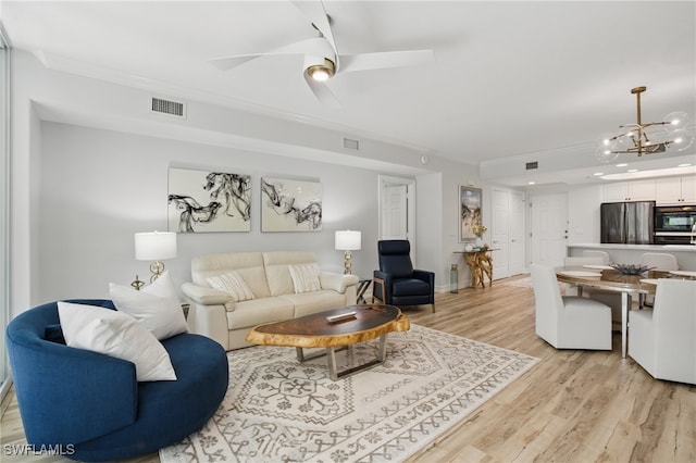 2728 Tiburon Blvd E Unit A104, Naples, FL 34109 - living room featuring ornamental molding, light wood-type flooring, a chandelier, and a ceiling fan