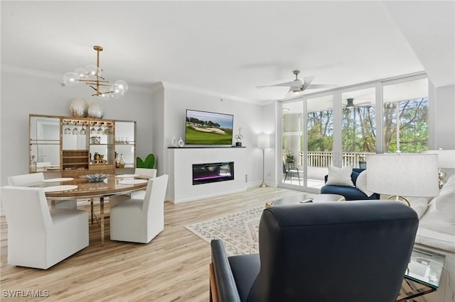 2728 Tiburon Blvd E Unit A104, Naples, FL 34109 - living area featuring crown molding, a chandelier, light wood-style floors, a glass covered fireplace, and a ceiling fan