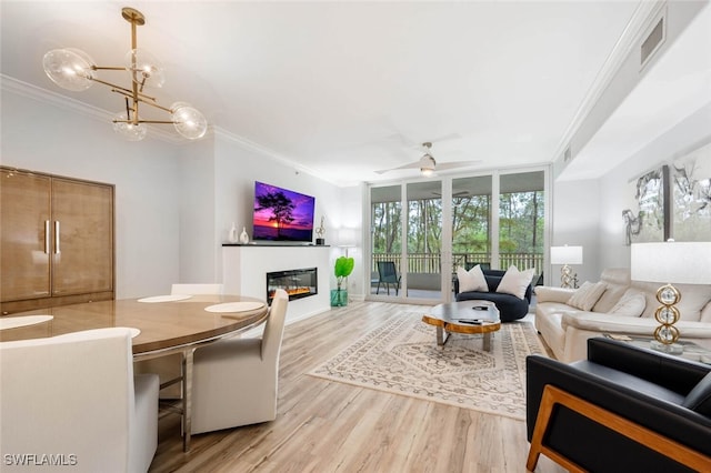 2728 Tiburon Blvd E Unit A104, Naples, FL 34109 - living room with ornamental molding, a glass covered fireplace, light wood-type flooring, a chandelier, and a ceiling fan