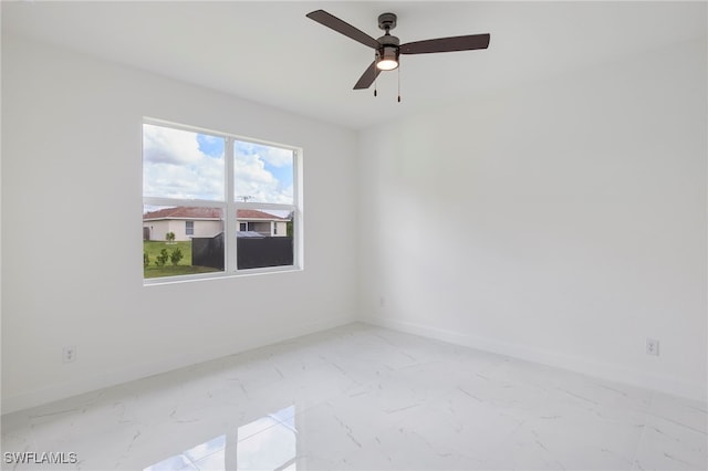 2809 54th St W, Lehigh Acres, FL 33971 - spare room with baseboards, marble look tiles, and a ceiling fan