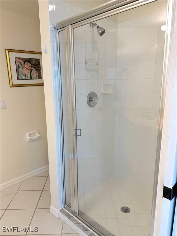8751 Estero Blvd W Unit 304, Bonita Springs, FL 33931 - full bathroom featuring a shower stall, tile patterned floors, and baseboards