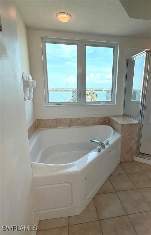 8751 Estero Blvd W Unit 304, Bonita Springs, FL 33931 - bathroom featuring tile patterned floors, a bath, and a shower stall