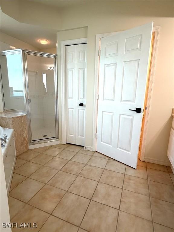 8751 Estero Blvd W Unit 304, Bonita Springs, FL 33931 - full bath with tile patterned floors, a shower stall, and a garden tub