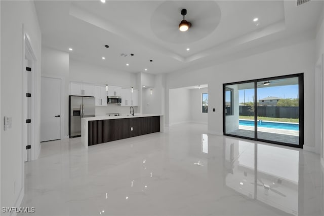 373 El Dorado Blvd S, Cape Coral, FL 33991 - unfurnished living room with a towering ceiling, a raised ceiling, ceiling fan, a sink, and plenty of natural light