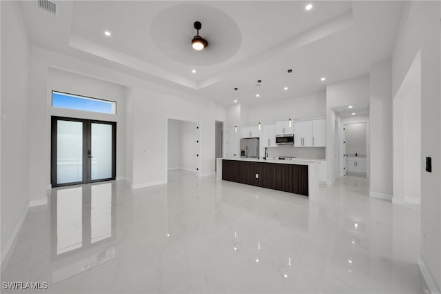 373 El Dorado Blvd S, Cape Coral, FL 33991 - unfurnished living room featuring a tray ceiling, baseboards, a high ceiling, recessed lighting, and a ceiling fan