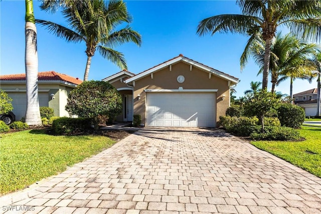 3905 Dunnster Ct, Fort Myers, FL 33916 - view of front facade featuring decorative driveway, stucco siding, a front yard, and an attached garage