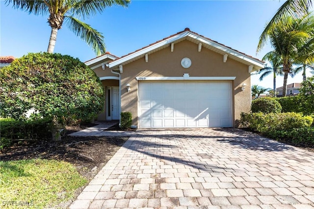 3905 Dunnster Ct, Fort Myers, FL 33916 - view of front of house with stucco siding, decorative driveway, and a garage