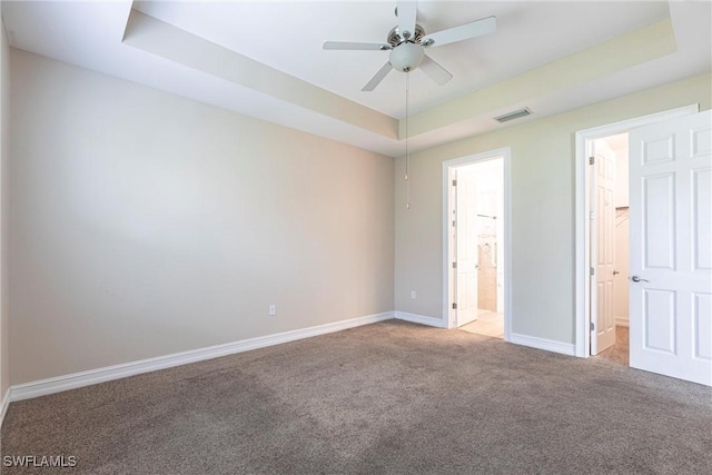 3905 Dunnster Ct, Fort Myers, FL 33916 - unfurnished bedroom with a raised ceiling, carpet flooring, baseboards, and ensuite bathroom