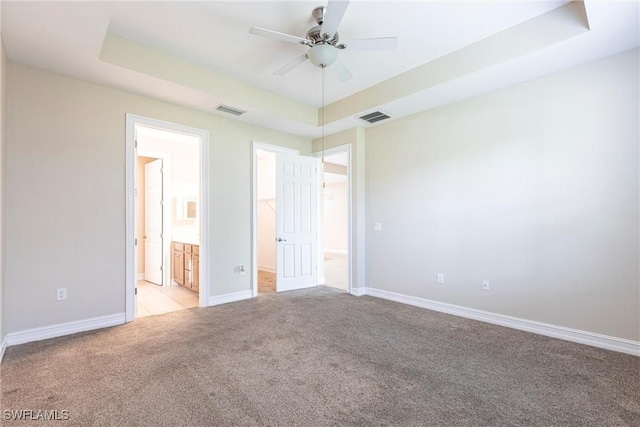 3905 Dunnster Ct, Fort Myers, FL 33916 - unfurnished bedroom featuring a raised ceiling, light colored carpet, a walk in closet, and baseboards