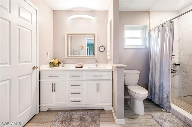 305 SW 8th St, Cape Coral, FL 33991 - bathroom featuring a marble finish shower, toilet, double vanity, and wood finished floors