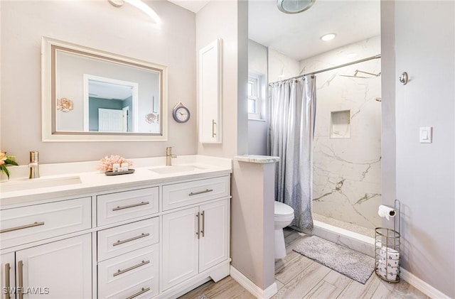 305 SW 8th St, Cape Coral, FL 33991 - bathroom featuring a marble finish shower, double vanity, toilet, and wood finished floors