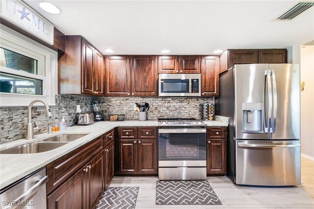 305 SW 8th St, Cape Coral, FL 33991 - kitchen featuring appliances with stainless steel finishes, a sink, backsplash, recessed lighting, and dark brown cabinets