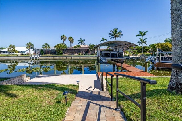 305 SW 8th St, Cape Coral, FL 33991 - dock area with boat lift, a lawn, and a water view