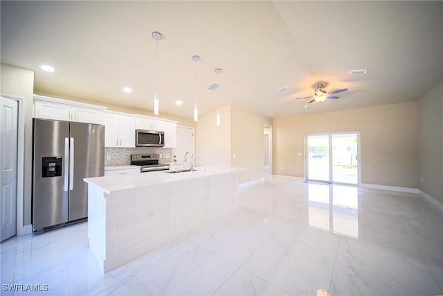 1962 Leghorn St, Lehigh Acres, FL 33972 - kitchen featuring appliances with stainless steel finishes, a sink, ceiling fan, white cabinets, and a center island with sink