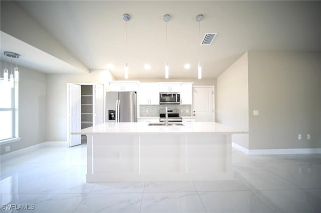 1962 Leghorn St, Lehigh Acres, FL 33972 - kitchen featuring stainless steel appliances, a center island with sink, white cabinetry, light countertops, and decorative backsplash