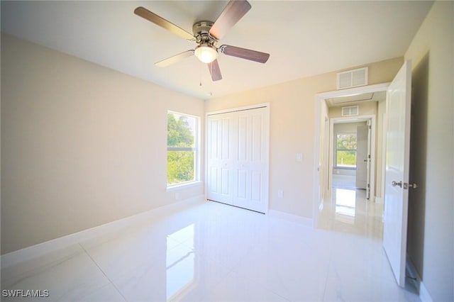 1962 Leghorn St, Lehigh Acres, FL 33972 - unfurnished bedroom with a closet, ceiling fan, tile patterned floors, and baseboards