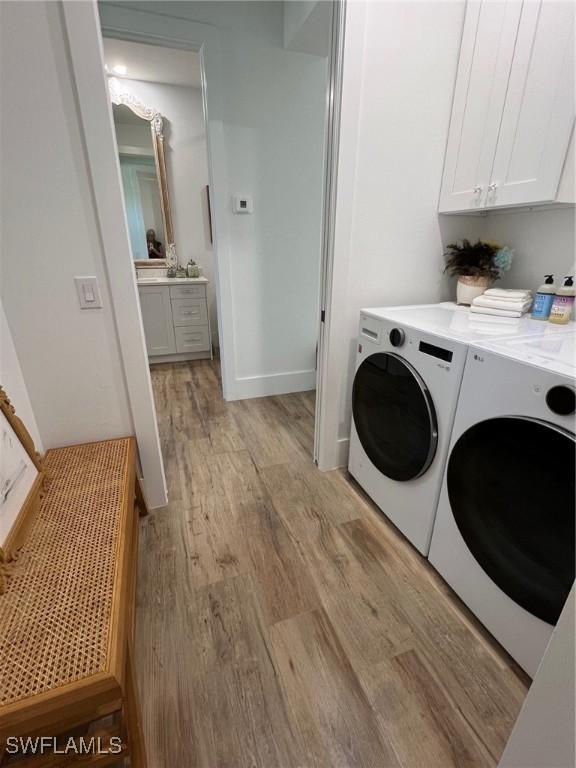 548 5th Ave, Marco Island, FL 34145 - laundry room with washing machine and dryer, cabinet space, and light wood finished floors