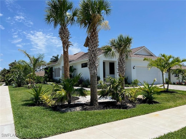548 5th Ave, Marco Island, FL 34145 - view of front facade with a garage, a front yard, concrete driveway, and stucco siding