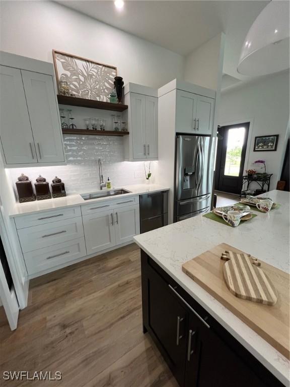 548 5th Ave, Marco Island, FL 34145 - kitchen with stainless steel fridge with ice dispenser, a sink, tasteful backsplash, light stone countertops, and open shelves
