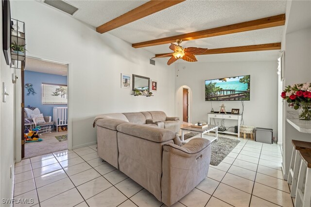 132 SW 34th Ln, Cape Coral, FL 33914 - living area with arched walkways, light tile patterned floors, beamed ceiling, a ceiling fan, and a textured ceiling