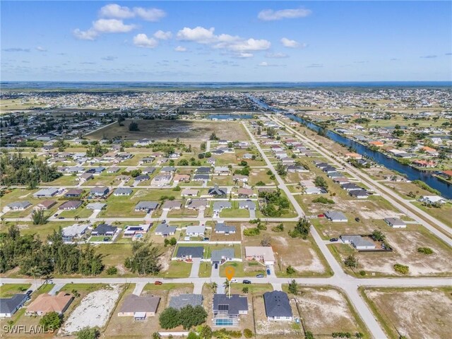 1233 NW 26th Pl, Cape Coral, FL 33993 - aerial view of property and surrounding area featuring a large body of water and nearby suburban area