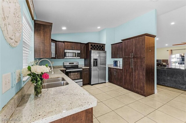 1233 NW 26th Pl, Cape Coral, FL 33993 - kitchen featuring stainless steel appliances, dark brown cabinets, light tile patterned floors, a sink, and vaulted ceiling