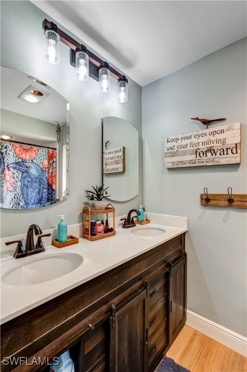 5692 Eichen Cir W, Fort Myers, FL 33919 - bathroom with double vanity and wood finished floors