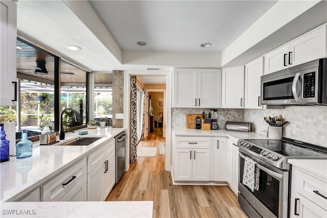 5692 Eichen Cir W, Fort Myers, FL 33919 - kitchen with stainless steel appliances, a sink, light wood-style floors, white cabinetry, and recessed lighting