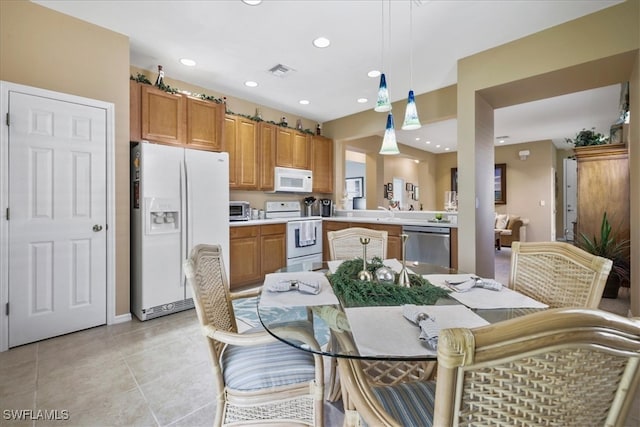 13180 SW Pembroke Cir, Lake Suzy, FL 34269 - kitchen featuring white appliances, light countertops, pendant lighting, brown cabinetry, and light tile patterned flooring