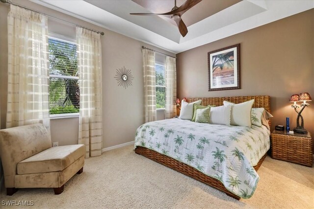 13180 SW Pembroke Cir, Lake Suzy, FL 34269 - bedroom featuring carpet flooring, baseboards, a tray ceiling, and ceiling fan