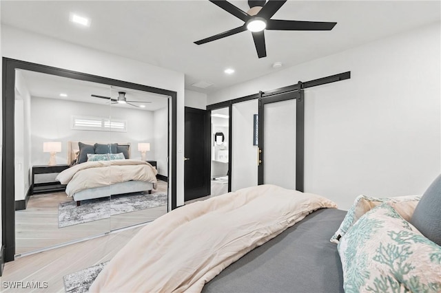 6212 Cocos Dr, Fort Myers, FL 33908 - bedroom with a barn door, wood finished floors, a ceiling fan, and recessed lighting