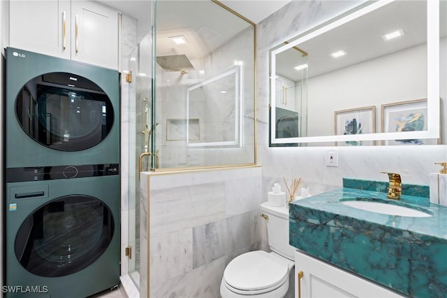 6212 Cocos Dr, Fort Myers, FL 33908 - bathroom featuring stacked washer / drying machine, tile walls, a stall shower, vanity, and toilet